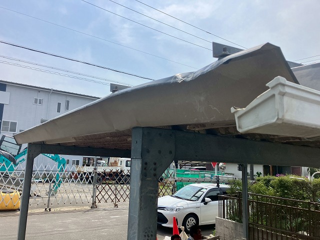 車両がぶつかって変形した折板屋根